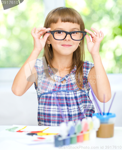 Image of Little girl is painting with gouache