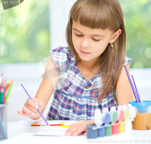 Image of Little girl is painting with gouache