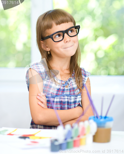 Image of Little girl is painting with gouache