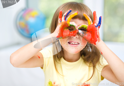 Image of Portrait of a cute girl playing with paints