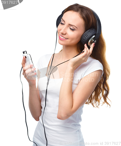 Image of Young woman enjoying music using headphones