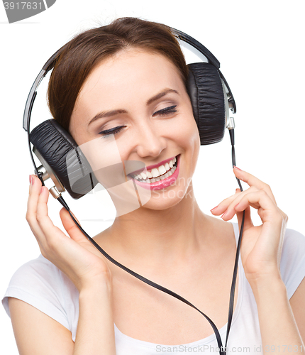 Image of Young woman enjoying music using headphones