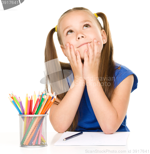 Image of Girl is daydreaming while drawing with pencils