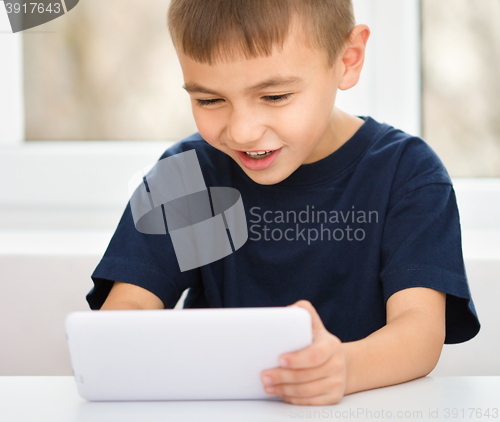 Image of Young boy is using tablet