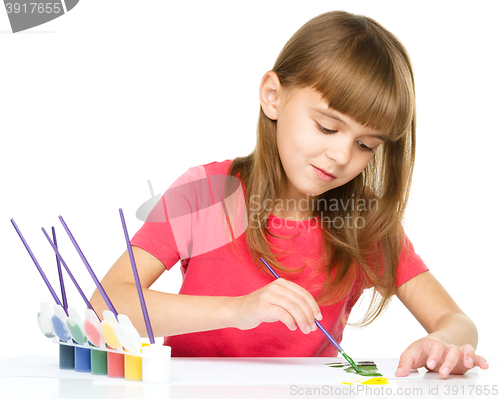 Image of Little girl is painting with gouache