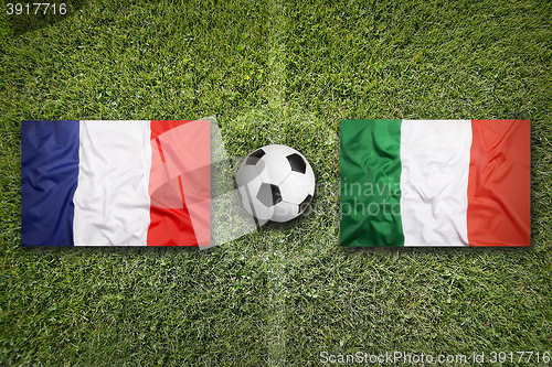 Image of France vs. Italy flags on soccer field