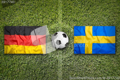 Image of Germany vs. Sweden flags on soccer field