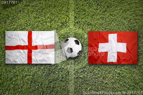 Image of England vs. Switzerland flags on soccer field