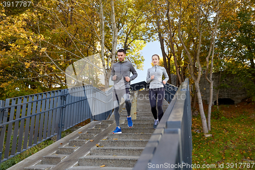 Image of happy couple running downstairs in city