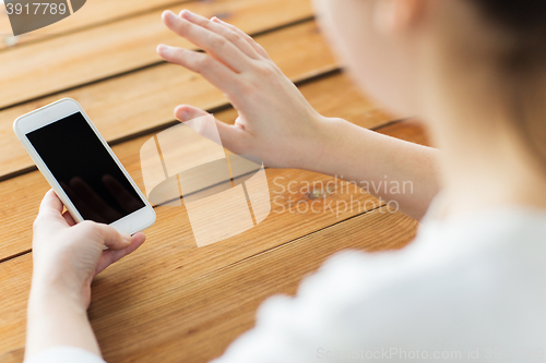 Image of close up of woman with smartphone waving hand