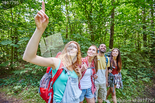 Image of group of smiling friends with backpacks hiking