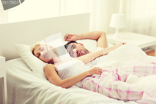 Image of happy couple sleeping in bed at home