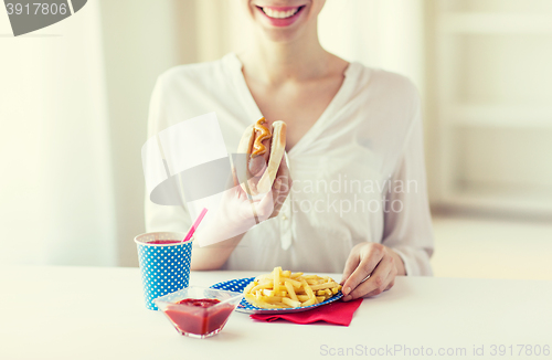 Image of close up of woman eating hotdog and french fries