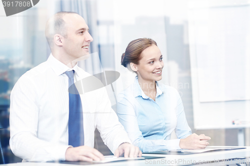 Image of group of smiling businesspeople meeting in office