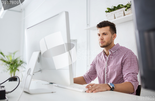 Image of creative man or student with computer at office