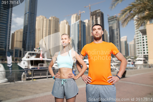 Image of couple exercising over dubai city background