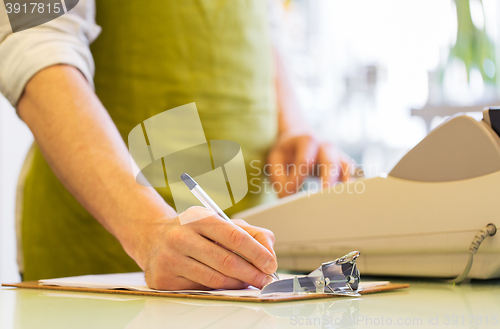 Image of close up of man with clipboard at flower shop