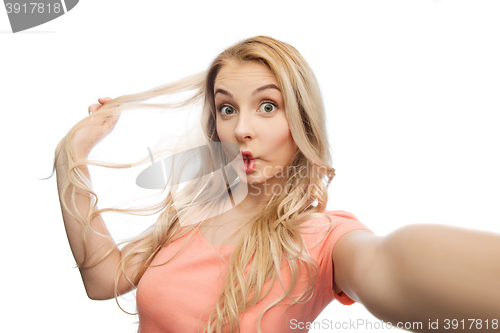 Image of young woman taking selfie and making fish face