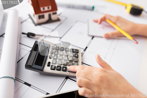 Image of close up of architect hand counting on calculator