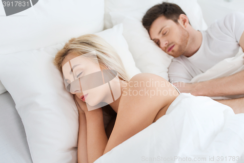 Image of happy couple sleeping in bed at home