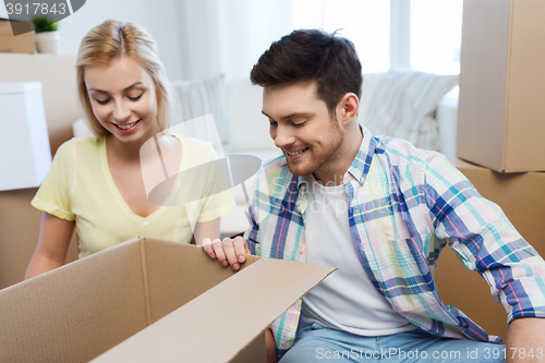 Image of smiling couple with big boxes moving to new home