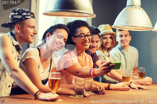 Image of happy friends with smartphone taking selfie at bar