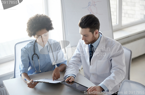 Image of doctors with tablet pc and clipboard at hospital