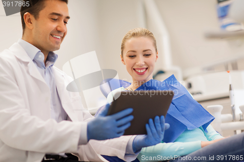 Image of male dentist with tablet pc and woman patient