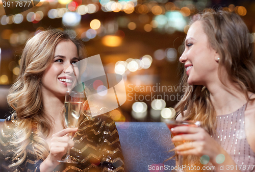 Image of happy women with drinks at night club