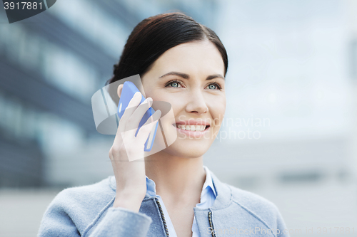 Image of young smiling businesswoman calling on smartphone