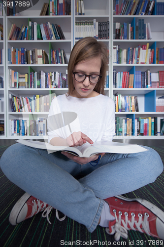 Image of female student study in library, using tablet and searching for 