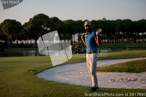 Image of golfer  portrait at golf course on sunset