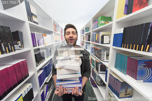 Image of Student holding lot of books in school library