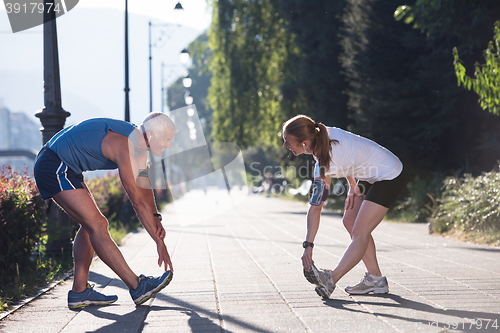 Image of couple warming up and stretching before jogging