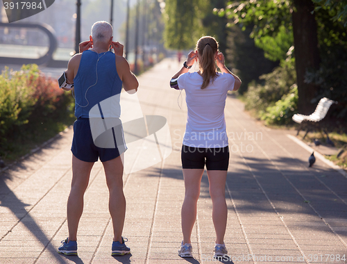 Image of jogging couple planning running route  and setting music