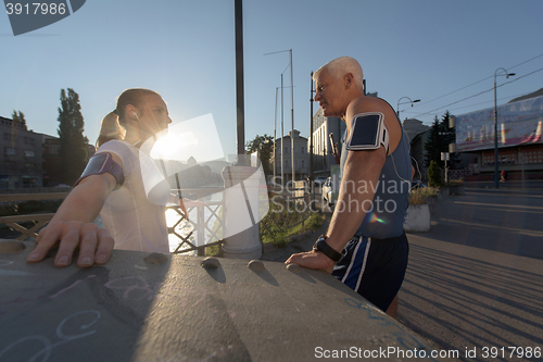 Image of jogging couple planning running route  and setting music