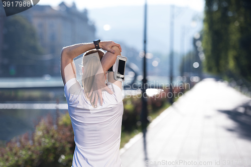 Image of blonde woman  stretching before morning jogging