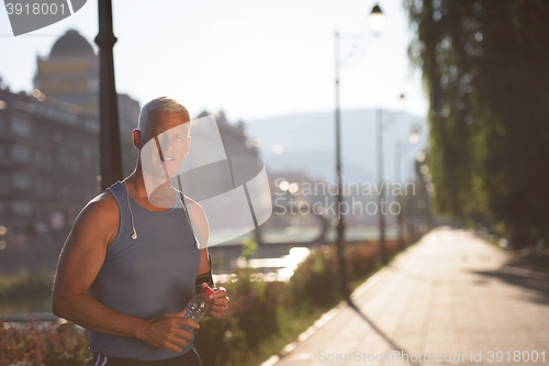 Image of portrait of handsome senior jogging man