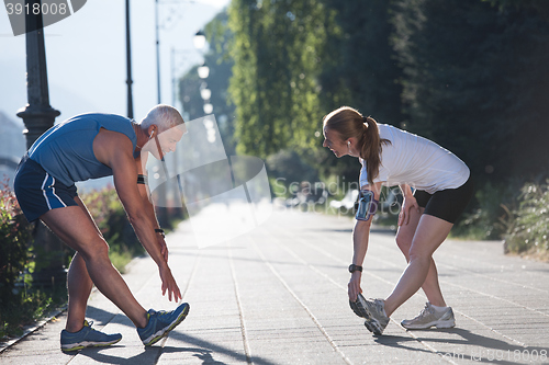 Image of couple warming up and stretching before jogging