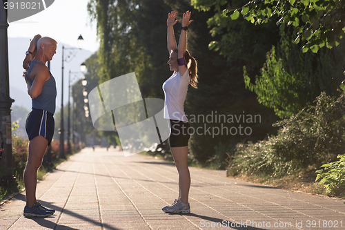 Image of couple warming up and stretching before jogging