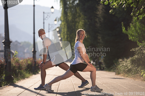 Image of couple warming up and stretching before jogging