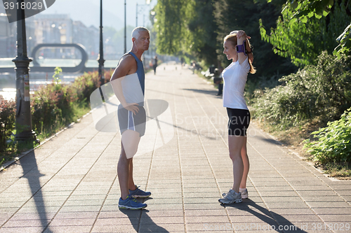 Image of couple warming up and stretching before jogging