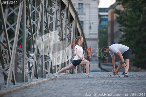 Image of couple warming up and stretching before jogging