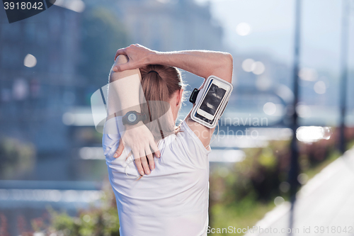 Image of blonde woman  stretching before morning jogging