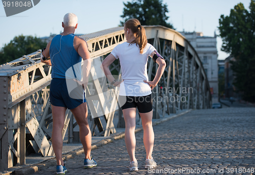 Image of jogging couple planning running route  and setting music