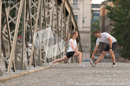 Image of couple warming up and stretching before jogging