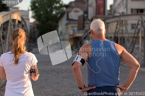 Image of jogging couple planning running route  and setting music