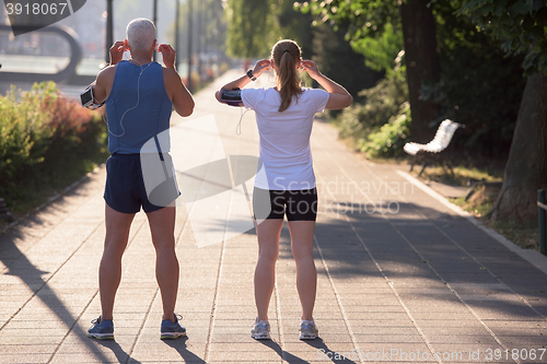 Image of jogging couple planning running route  and setting music