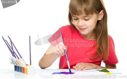 Image of Little girl is painting with gouache