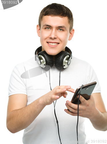 Image of Young man enjoying music using headphones